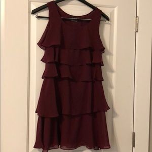 A maroon shift dress with ruffles.